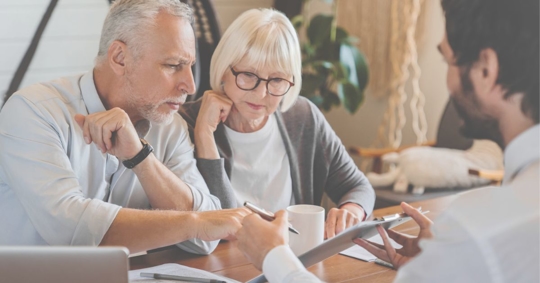 two older people going over a document with an attorney