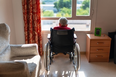 Elderly woman alone in her room and looking out the window | Obenshain Law Group